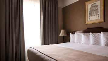 Una camera d'albergo con un letto grande, una lampada e un quadro incorniciato al muro.