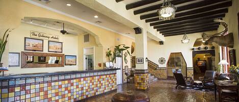 A lobby with a tiled floor, a reception desk, and a sign for The Gateway Hotels.