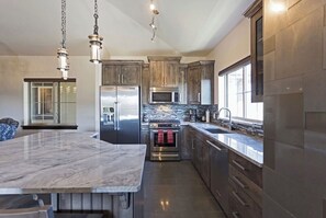 Enjoy cooking in this well-equipped kitchen with a large island, stainless steel appliances, and ample natural light.