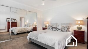 A bedroom with a large mirror, two beds, and bedside lamps. - Simplicity & Serenity *1 NIGHT FREE* Charming Retreat, no Govt Tax (Blairgowrie)