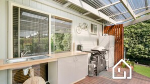 A modern kitchen with a wooden deck, a built-in sink, and a grill. - Simplicity & Serenity *1 NIGHT FREE* Charming Retreat, no Govt Tax (Blairgowrie)