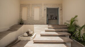 A modern interior with a staircase leading to a second floor, a skylight, and a view of a kitchen area. - Margarett Hotel (Valladolid)