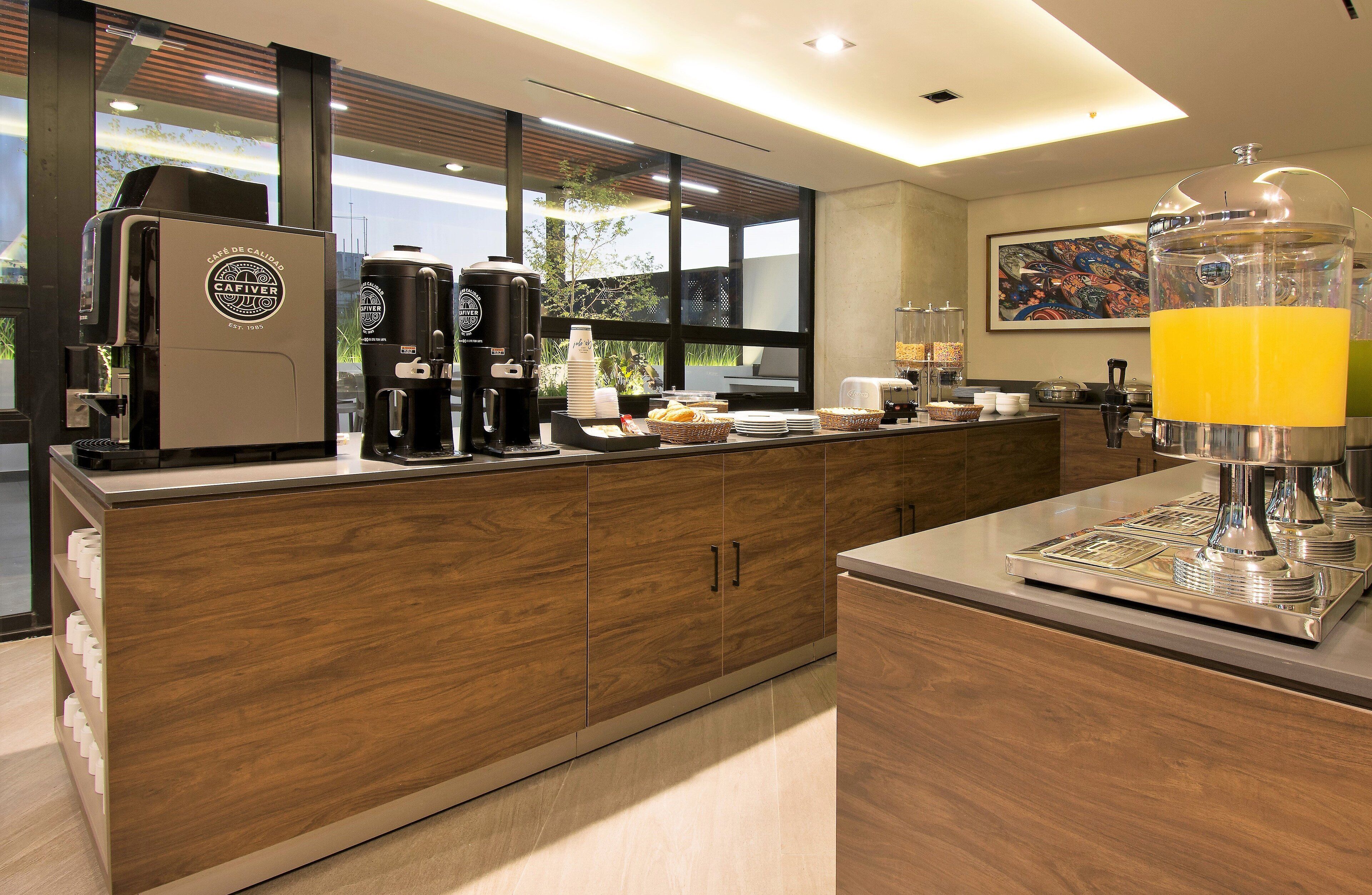 A modern kitchen with a coffee station, including a coffee maker, a grinder, and a blender.