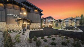 A hotel with a stone facade, named SPRINGHILL SUITES, featuring a modern design with multiple units and a landscaped entrance. - SpringHill Suites by Marriott Island Park Yellowstone (Island Park)