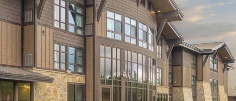 A large building with multiple windows and a patio area with outdoor seating.