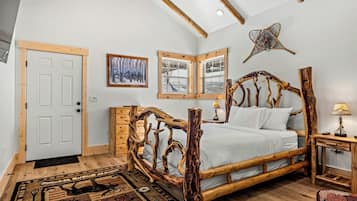 A bedroom with a wooden bed frame, a window with a view, and a door.