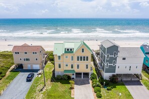 A row of houses by the beach with a view of the ocean.