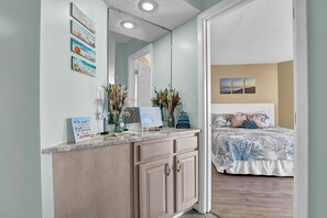 A bedroom with a bed, a nightstand, and a mirror.