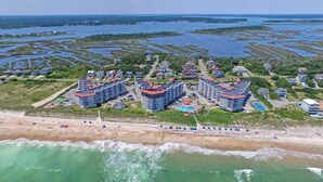 Una località balneare con diversi edifici a più piani, una spiaggia sabbiosa e un porto turistico.