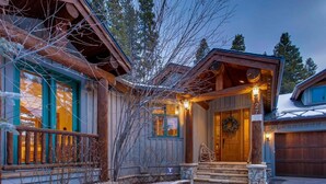 A log cabin with a stone entrance, wooden porch, and a garage. - Beaver's Lodge (Breckenridge)