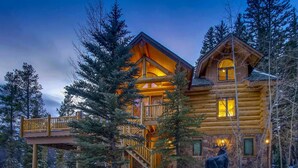 Une cabane en rondins dotée d’une terrasse en bois et d’un escalier menant à l’étage supérieur.