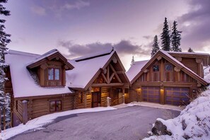 A log cabin with a garage and a covered porch.