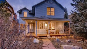 A two-story house with a porch, a covered entryway, and a stone pathway leading to the front door. - Hideaway on High (Breckenridge)