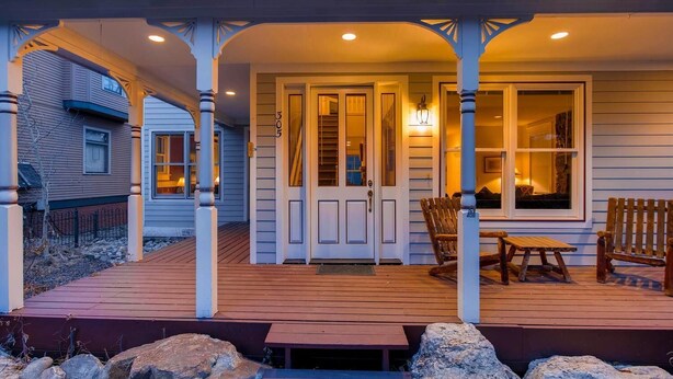 A covered porch with a wooden deck, a bench, and a table. - Hideaway on High (Breckenridge)
