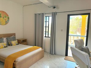 Une chambre à coucher avec un lit, une table de chevet, une chaise et une vue sur l’extérieur.