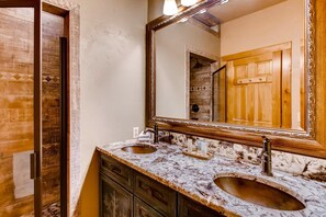 A bathroom with two sinks, a large mirror, and wooden cabinetry. - Ski Classic Lodge (Breckenridge)