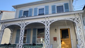 A two-story house with a porch, a front door, and a mailbox. - The Strand House with hot tub (Kingston)