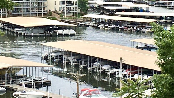 A marina with multiple docks and boats, surrounded by lush green trees. - GREAT LAKEVIEW  LOCATION WITH TROPICAL VIBES (Lake Ozark)