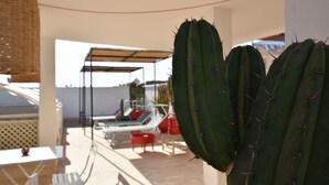 A patio area with a white table, red chairs, and a covered seating area. - Miostello Lifestyle Riad Marrakech (Marrakech)