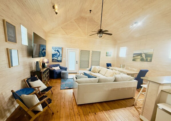 A spacious room with a large bed, a desk, and a TV mounted on the wall.
