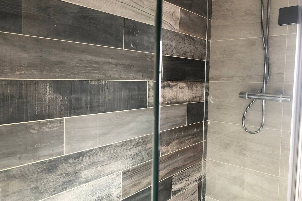 A shower area with a glass partition and a showerhead.