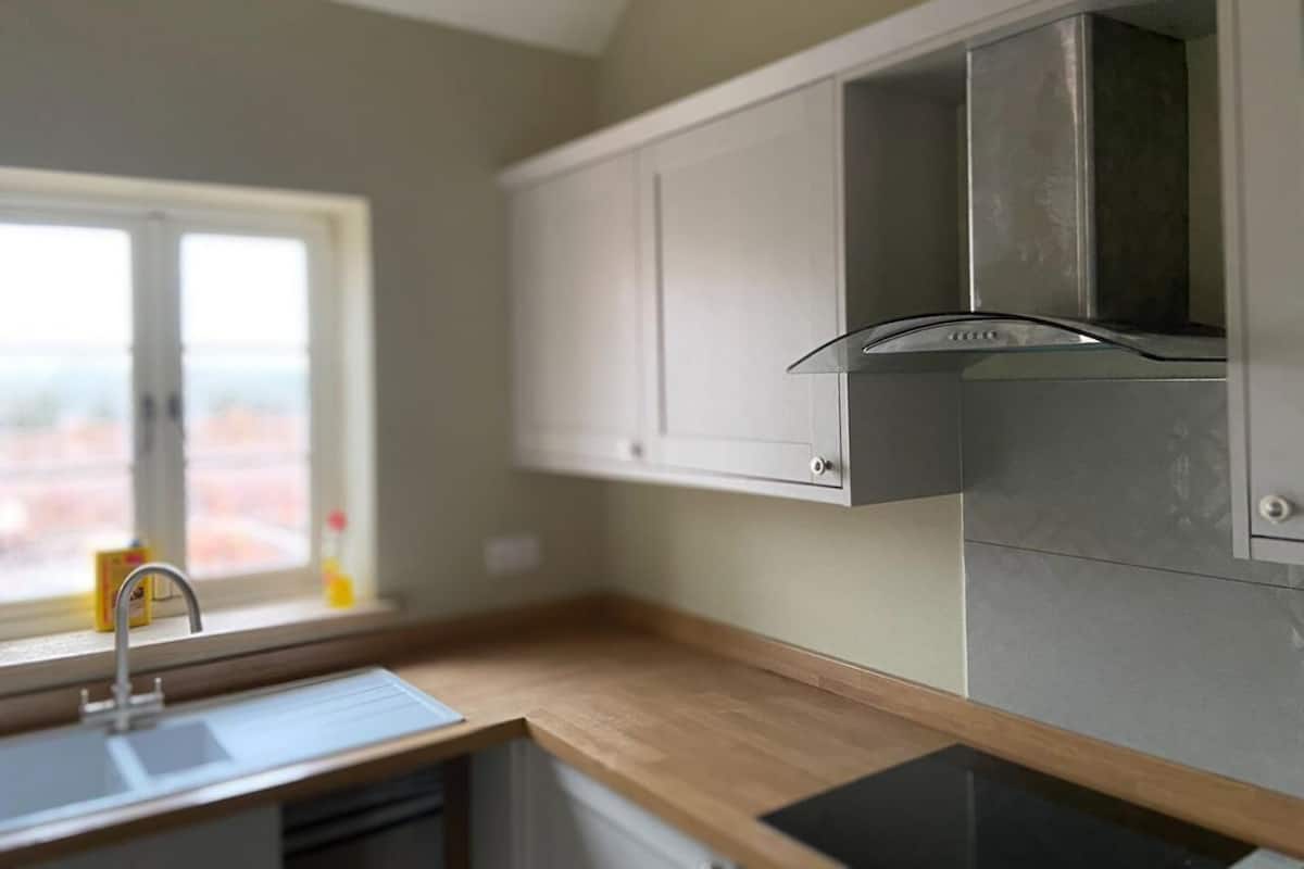 A kitchen with a window, a sink, and cabinets.
