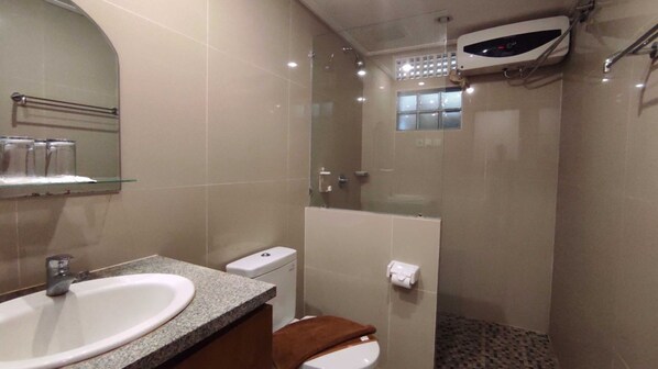 Un baño con lavamanos, inodoro y ducha.