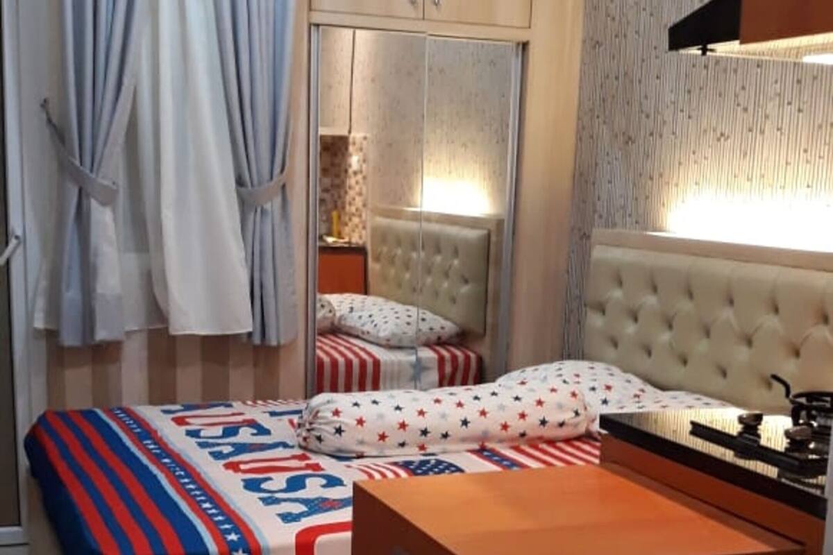 Une chambre à coucher comprenant un lit, un bureau, un miroir et une armoire.