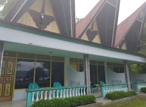 A building with a covered porch, large windows, and a traditional architectural style. - Marroan Guest House (Samosir)