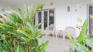 A room with a tiled floor, a wooden door, and two wooden chairs. - Karan Homestay Canggu (Canggu)
