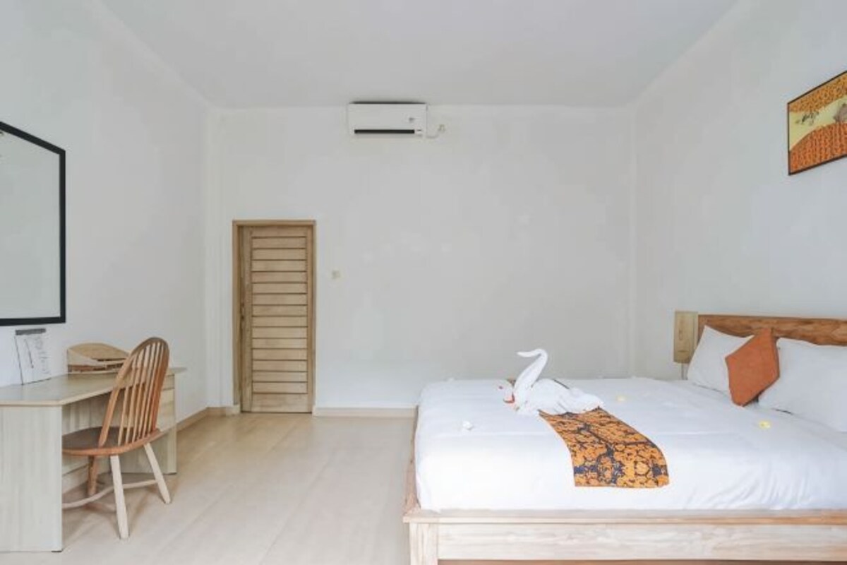 A bedroom with a bed, a desk, and a chair.