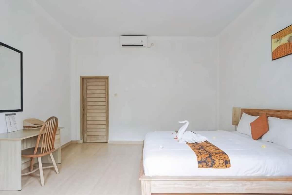 Um quarto com uma cama, uma mesa e uma cadeira.