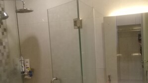 A modern bathroom with a glass-enclosed shower, a white sink, and a mirror above it. - Luxury Living At The Edge (Cimahi)