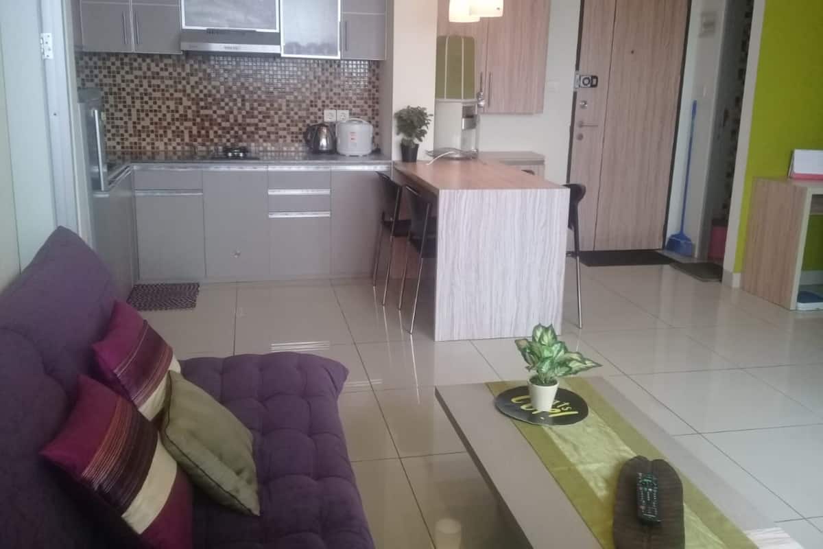A modern kitchen with grey cabinets, a tiled backsplash, and a dining area with a wooden table and chairs.