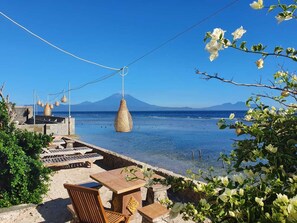 A seaside terrace with a view of the sea and a mountain in the distance. - Waterside Inn Nusa Penida (Penida Island)