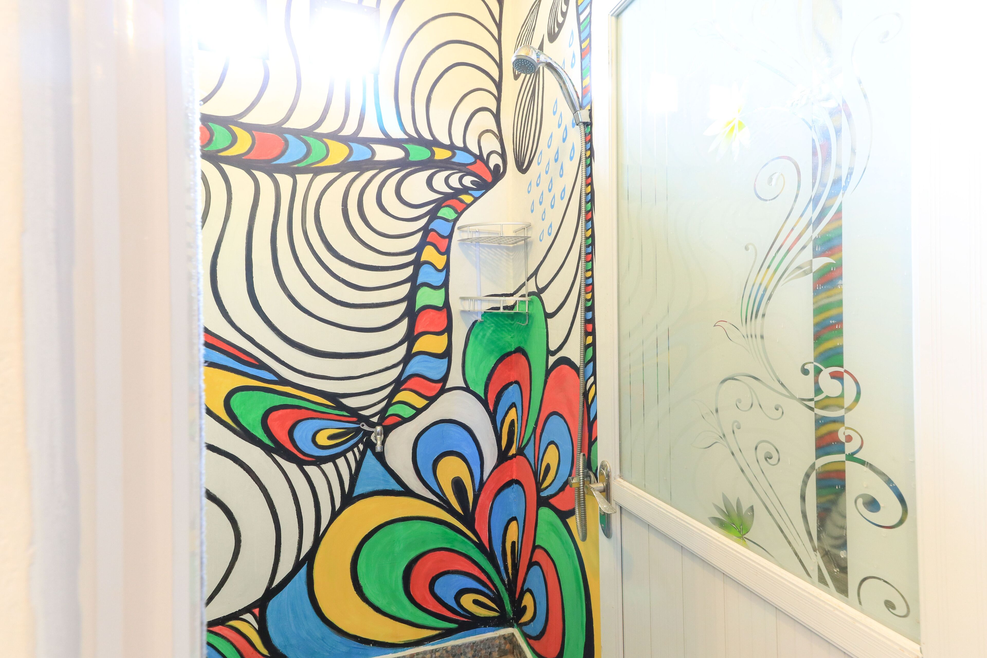 A bathroom with colorful abstract wall art and a shower area.