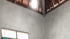 A room with a single bed, a window with a green curtain, and a tiled floor. - Mas Bangkrenx Homestay (Depok)