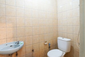A bathroom with a sink, toilet, and tiled walls.
