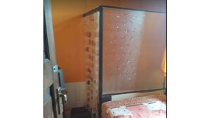 A bedroom with a bed, a wardrobe, and a radiator. - Caisar Homestay (Sidoarjo)