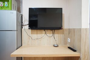 Enjoy cooking and entertainment in this compact kitchenette with a refrigerator and flat-screen TV.