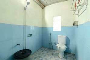 A small bathroom with a toilet, a shower, and a sink.