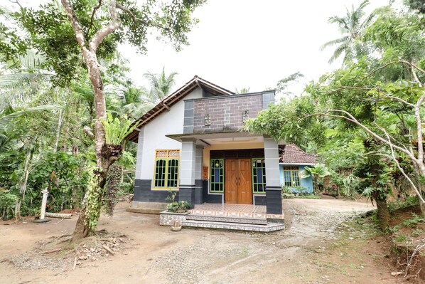 A two-story house with a tiled entrance and a small porch.