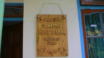 A wooden sign with the text "Homestay MBAN PARK" and "Segafredo Pizzeria" on a wall.