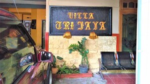 A building entrance with a sign reading "VILLA TRIJAYA" and a parked car. - Villa Trijaya (Batu)