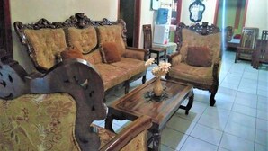 A traditional living room with a sofa set, a coffee table, and a decorative vase. - Villa Trijaya (Batu)