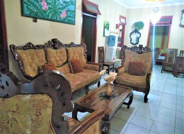 A traditional living room with a sofa set, a coffee table, and a decorative vase.