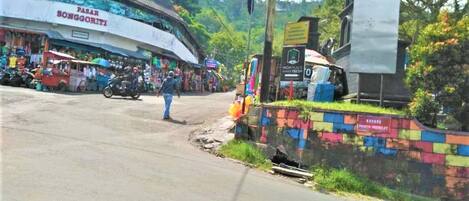 A street scene with a building labeled 'PASAR SONGGORITI' and a colorful wall with a sign 'KULING PARZIN MENOLET'.