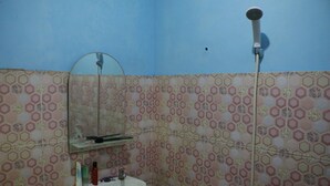 A bathroom with a sink, mirror, and shower. - Suparman Homestay - Hostel (Kokap)