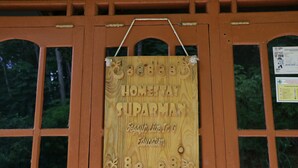 A wooden sign with the text "Homestay Suparman" and "Segah Live In & Education" on a window. - Suparman Homestay - Hostel (Kokap)