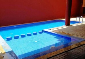 A swimming pool with a blue tiled floor and a red wall in the background. - La Kasbah de Marrakech Residence 4639 (Marrakech)